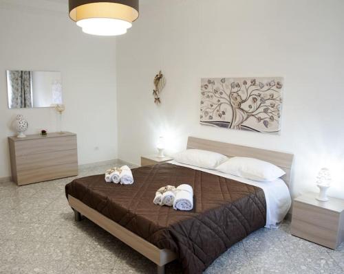 een slaapkamer met een groot bed en handdoeken bij Il mare in città. Appartamento vista mare in Monopoli