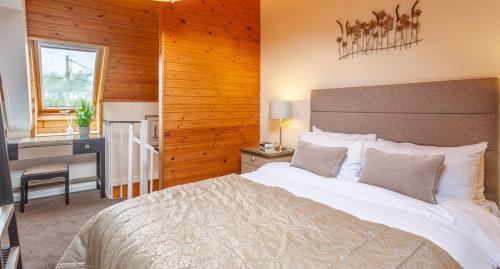 a bedroom with a large bed with a desk and a desk at Anglers Arms in Alnwick
