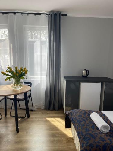 a bedroom with a bed and a table with a vase of flowers at Pałac Zegrzyński in Zegrze