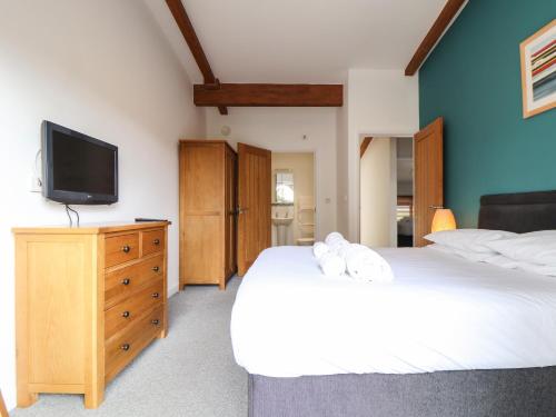a bedroom with two beds and a tv on a dresser at 11 Towan Valley in Truro