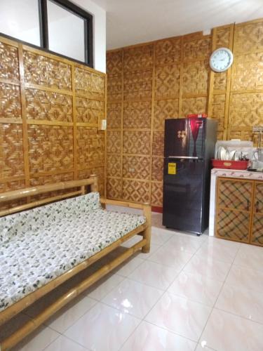 a room with a bed and a refrigerator in it at Felipa Beach Residence - Jasmine in Dumaguete