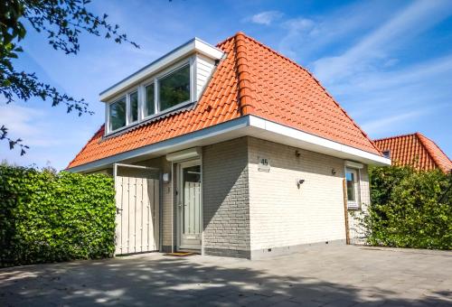 une petite maison avec un toit orange dans l'établissement VacationVilla Noordwijk, à Noordwijk