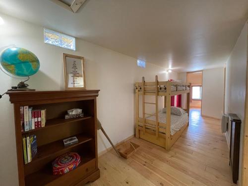a room with a book shelf and a bunk bed at L'ancienne étable in Brens