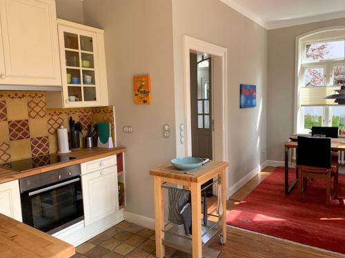 a kitchen with white cabinets and a table with a bowl on it at Waldmühle in Schleswig