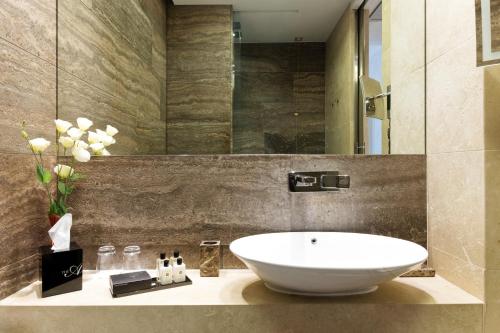a bathroom with a white sink and a mirror at The Ashbee Hotel in Taormina