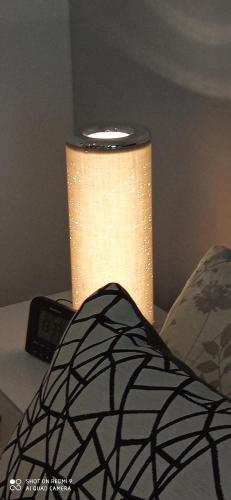 a lamp sitting on a table next to a pillow at Apartment Kleine Koje in Hedwigenkoog