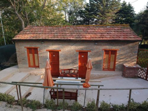 a small house with chairs and umbrellas in front of it at Casale Valentini in Fermo