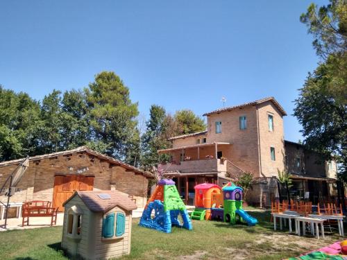podwórko ze sprzętem do zabawy i domem w obiekcie Casale Valentini w mieście Fermo