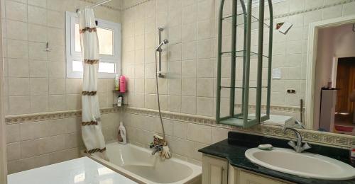a bathroom with a tub and a sink and a mirror at شاليه بحديقة يري البحر , بانوراما بيتش ريزورت , الساحل الشمالي The North Coast , Sea View Garden Chalet in El Alamein