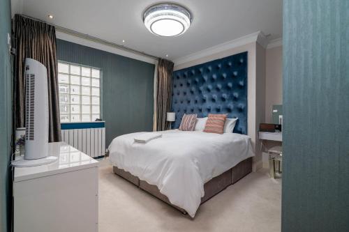 a bedroom with a large bed and a blue wall at GuestReady - Extravagant 2BR Apt in London in London