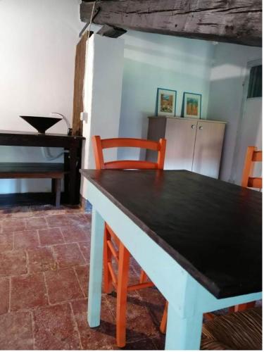 a table and chairs in a room with a piano at Casale Valentini in Fermo