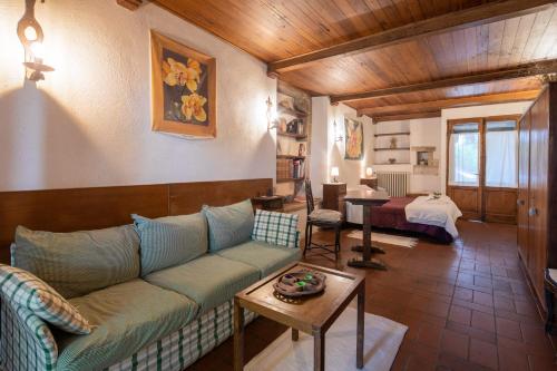 una sala de estar con un sofá y una mesa en Stone built farmhouse Antica Torre by VacaVilla, en Lamole