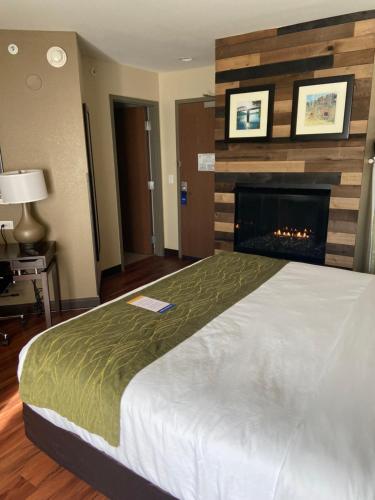 a hotel room with a bed and a fireplace at Comfort Inn Connellsville Riverview in Connellsville