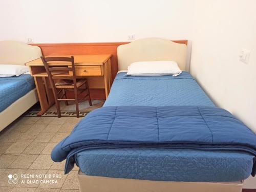 a bedroom with a blue bed and a desk at Soggiorno Emanuela in Rome