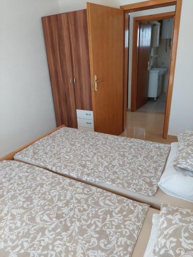 two twin beds in a room with a hallway at Apartman Vučemil in Orebić