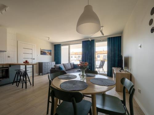 a living room and kitchen with a table and chairs at Apartament Baltic Sunrise in Sztutowo