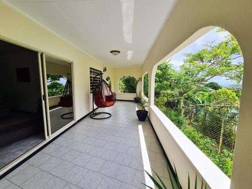 an indoor balcony with a view of the garden at Charming house with sea view in Souvenir - 200 m² - Terrace in Misere