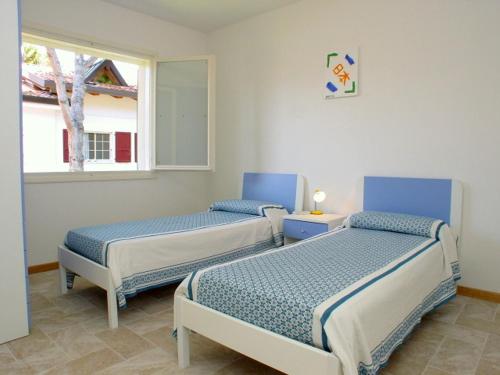 2 camas en una habitación con ventana en Flat in Lignano Riviera, en Lignano Sabbiadoro