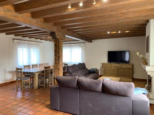 uma sala de estar com um sofá e uma mesa em Los Arenales de Arcones em Colladillo