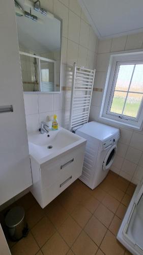 a white bathroom with a sink and a washing machine at Seacottage Brugge - Blankenberge - De Haan in De Haan