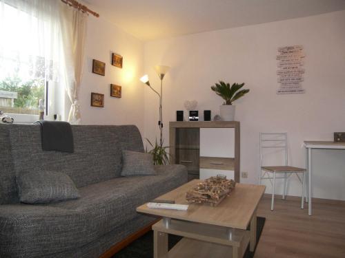 Una sala de estar con un sofá y una mesa de café. en Bungalow Vincent mit Terrasse, Grill & WLAN, en Zempin