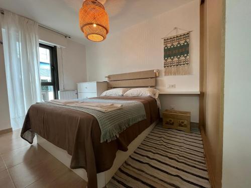 sypialnia z dużym łóżkiem z dywanem w obiekcie Apartamento con terraza,2 min de la playa, Ares w mieście Ares