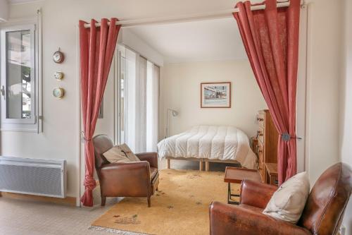 - un salon avec des rideaux rouges et un lit dans l'établissement 70m de la mer ! Appartement pour 4 à La Baule, à La Baule