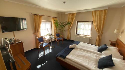 A bed or beds in a room at Zámecký Hotel Zlatý Orel