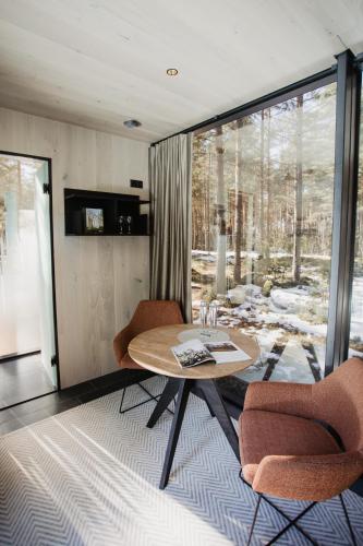 Habitación con mesa, sillas y ventana en ÖÖD Hötels Laheranna SUME -with sauna en Punakivi