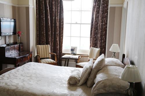 a hotel room with a bed and a window at Walpole Bay Hotel in Margate