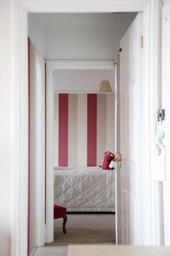 a bedroom with a bed with red and white stripes at Walpole Bay Hotel in Margate