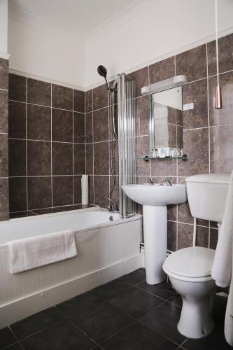a bathroom with a tub and a sink and a toilet at Walpole Bay Hotel in Margate