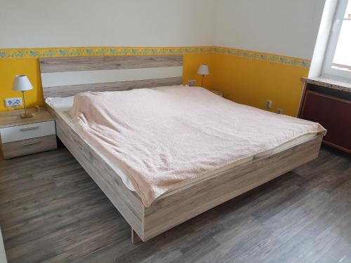 グレーミッツにあるFerienwohnungen Öker - Whg 1 - familiengerechte Fewo mit 2 SZ, nur wenige Gehminuten zum Hauptstrandの黄色い壁の客室の大型ベッド1台分です。