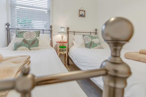 a bedroom with two beds and a mirror at Jurassic View Apartment in Lyme Regis