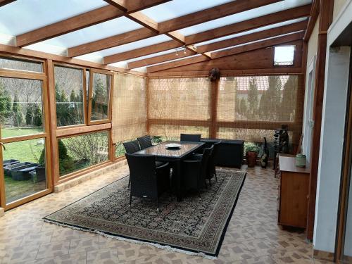 a large screened in porch with a table and chairs at Apartamenty pod Dzikowcem in Boguszów-Gorce