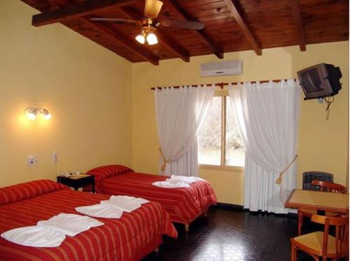 ein Hotelzimmer mit 2 Betten und einem Fenster in der Unterkunft Hotel El Hornero Spa in Merlo