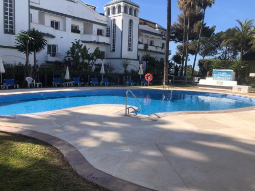 a swimming pool in front of a large building at Dominion Beach House in Estepona