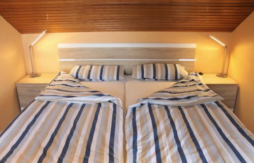 グレーミッツにあるFerienwohnungen Öker - Whg 3のベッドルーム(ストライプ枕付)2台
