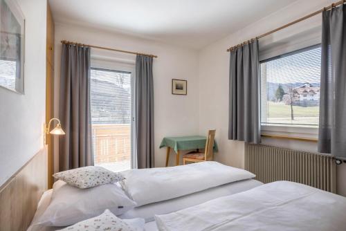 een hotelkamer met 2 bedden en een raam bij Unterhauserhof App A in Valdaora