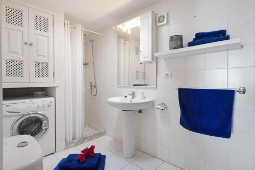 Un baño con lavabo y lavadora. en Puerto Chico X, en Playa Blanca