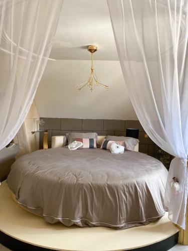 a bedroom with a large bed with white curtains at il piccolo castello in Méjannes-lès-Alès