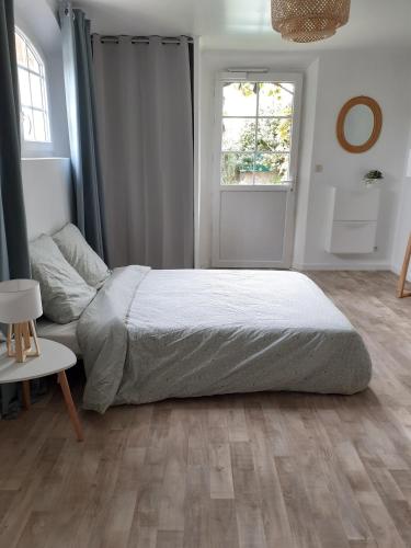 une chambre avec un grand lit et une fenêtre dans l'établissement superbe grand studio tout confort avec exterieur, à Poussan