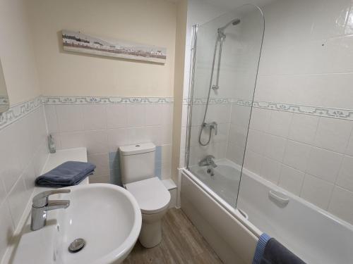 a bathroom with a toilet and a sink and a shower at 28 Anchorage Way in East Cowes