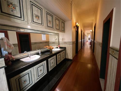 a large bathroom with two sinks and a mirror at Pousada do Duque in Lambari