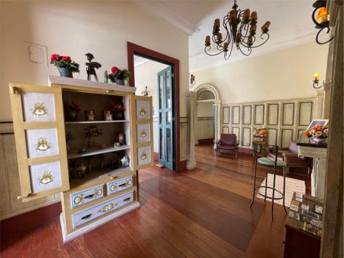 a living room with a wooden floor and a dining room at Pousada do Duque in Lambari