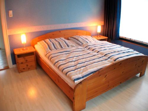 グレーミッツにあるFerienwohnungen Öker - Whg 4の木製ベッド1台(2つのテーブルにランプ2つ付)