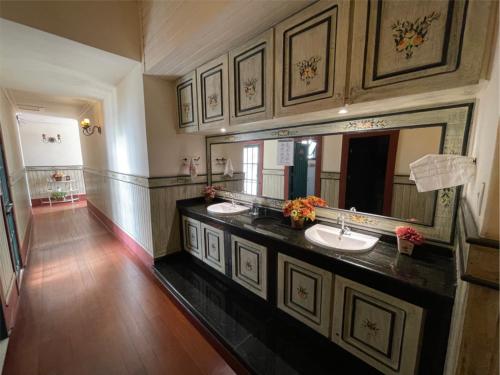 baño grande con 2 lavabos y espejo grande en Pousada do Duque en Lambari