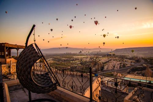 a group of hot air balloons flying in the sky at Simera in Cappadocia - Special Class - Best View Rooftop in Uchisar