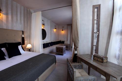 a hotel room with a bed and a table and a desk at Riad Joya in Marrakesh