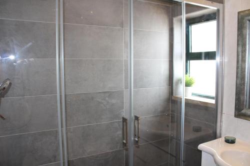 a shower with a glass door in a bathroom at Apartamento Urb. Vila Nova, Lote 5 in Armação de Pêra